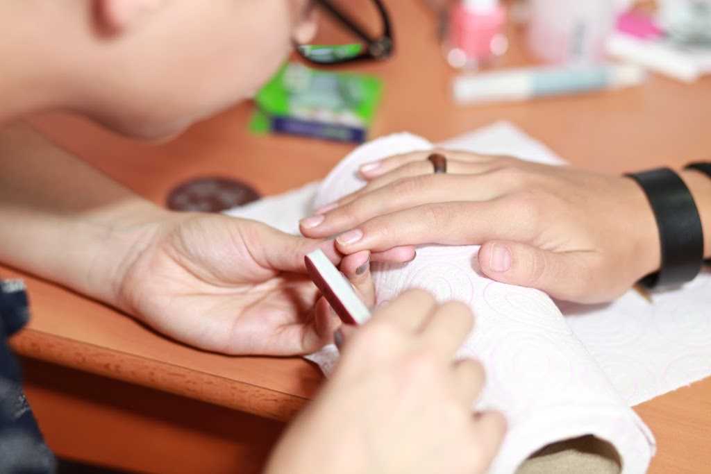 nailistas realizando una manicura para un baby shower